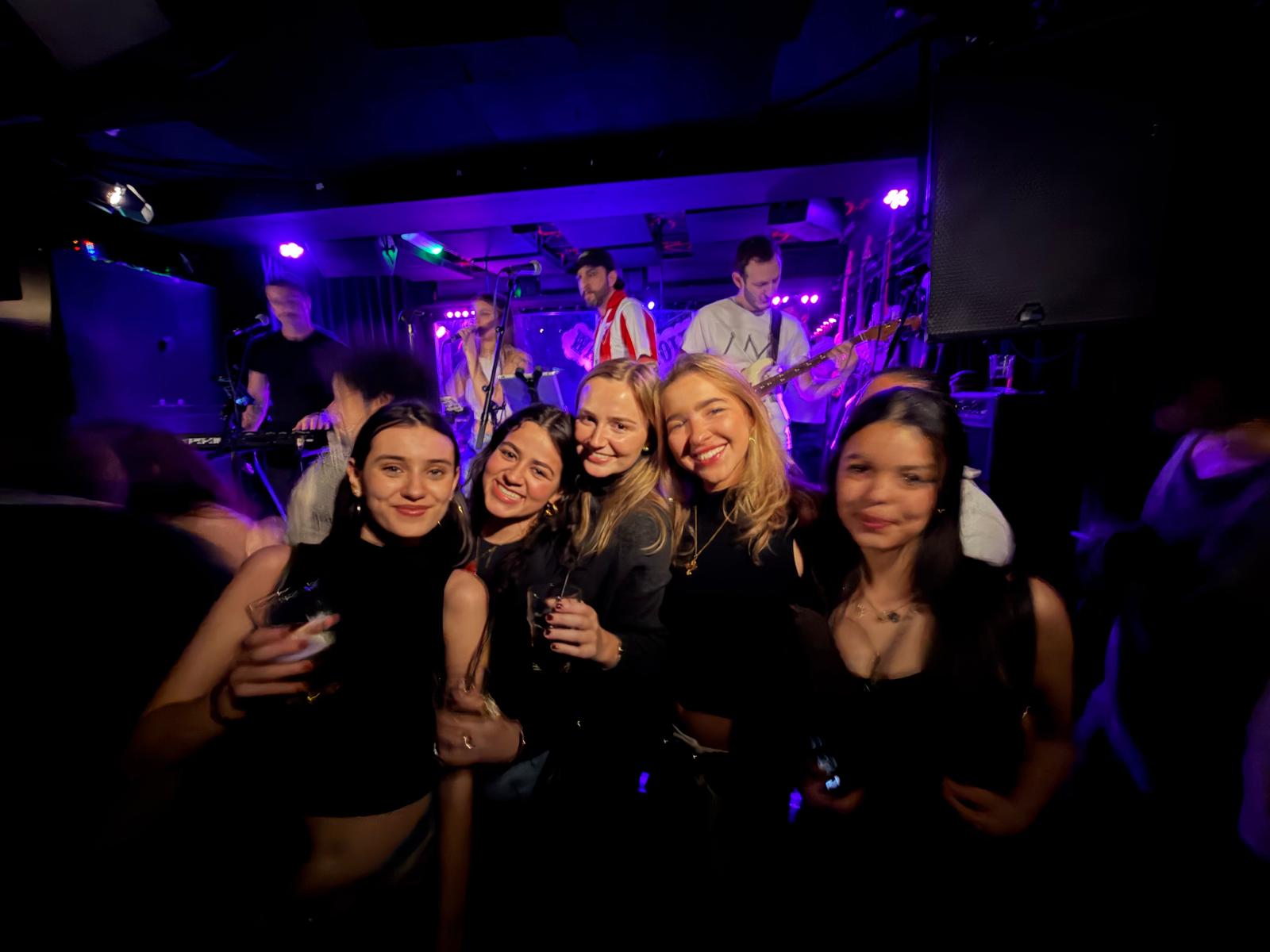 Friends smiling together in front of a live band