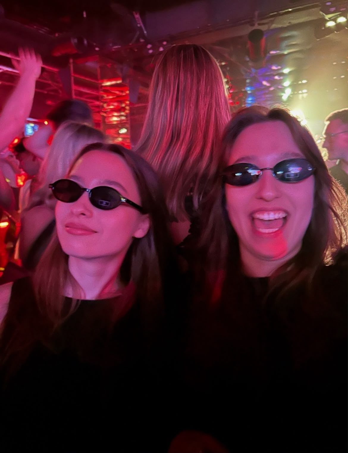 Two friends enjoying a crowded nightclub