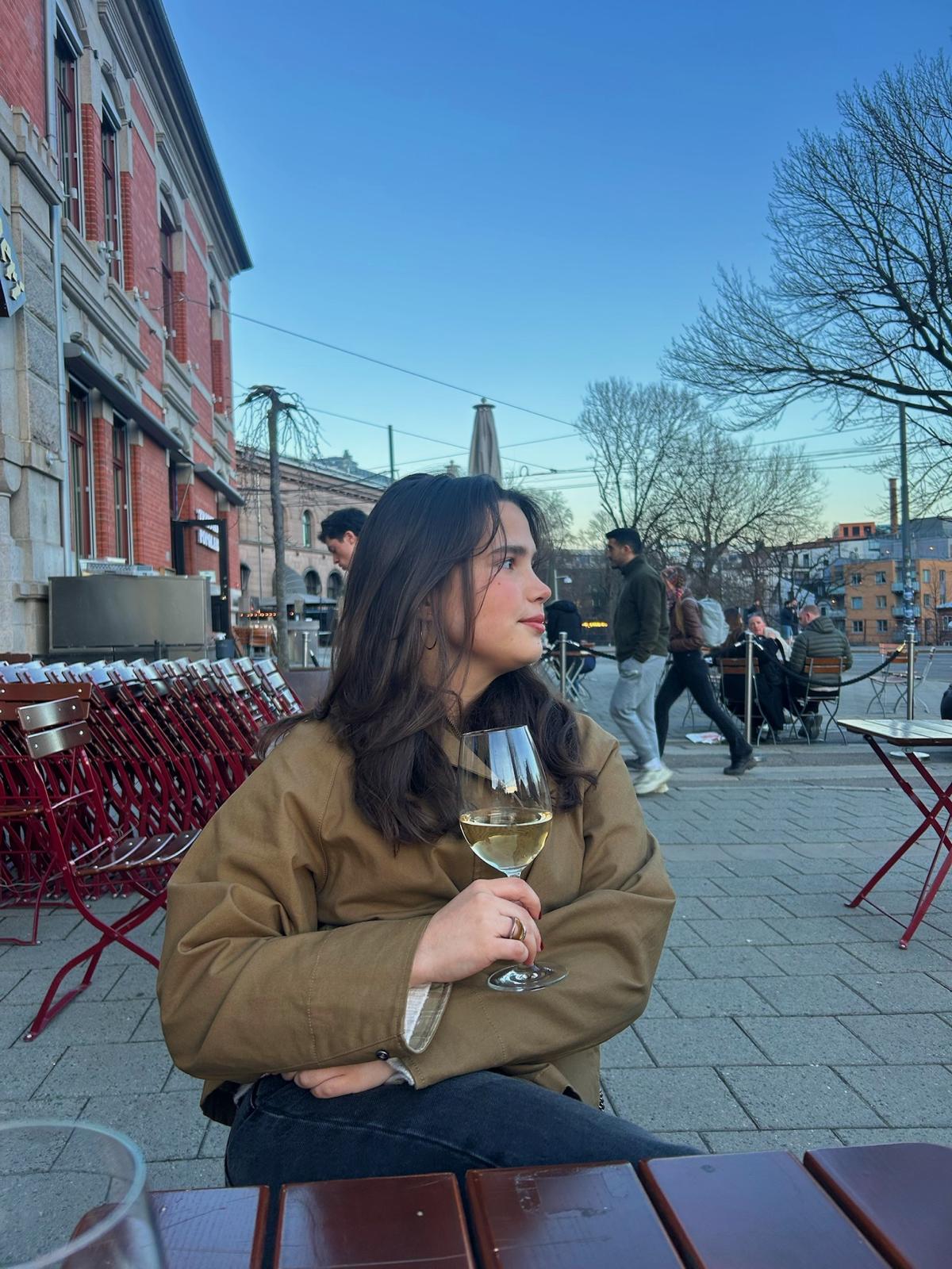 A guest enjoying wine at an outdoor Oslo table